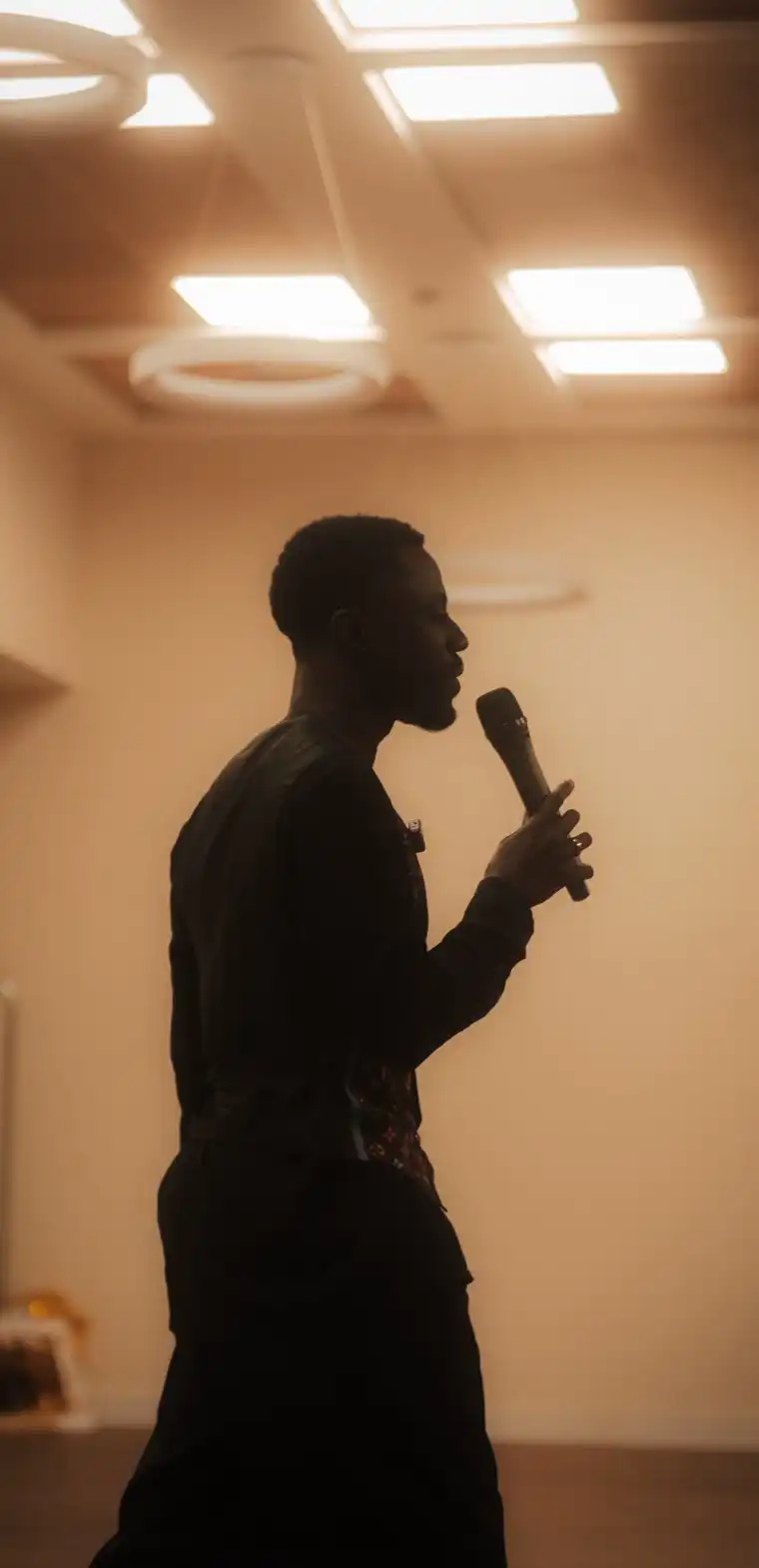 Tonio Amoah hablando con un micrófono a contraluz